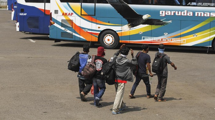 Sejumlah calon penumpang bersiap naik bus di area Terminal Jatijajar, Depok, Jawa Barat, Kamis (23/4/2020). Pemerintah memutuskan kebijakan larangan mudik Lebaran 2020 bagi masyarakat mulai berlaku Jumat (24/4) guna memutus mata rantai penyebaran COVID-19. ANTARA FOTO/Asprilla Dwi Adha/aww.