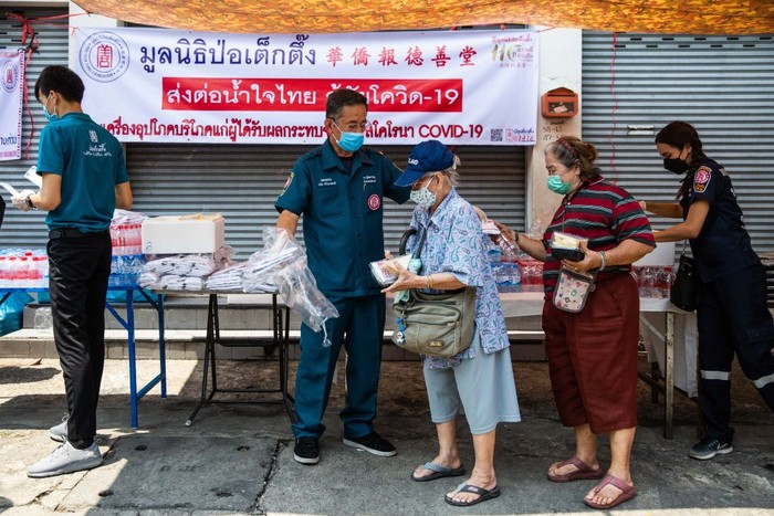 antri Paket Makan Gratis Warga pemukiman padat penduduk Pathumwan mengantri pembagian makanan, air mineral dan masker di Bangkok, Thailand (22/4/2020). Pembagian paket makanan berlangsung tertib, tetap menjaga jarak, tidak berdesak-desakan. Patut ditiru.