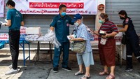 Warga pemukiman padat penduduk Pathumwan mengantri pembagian makanan, air mineral dan masker di Bangkok, Thailand (22/4/2020). Pembagian paket makanan berlangsung tertib, tetap menjaga jarak, tidak berdesak-desakan. Patut ditiru.