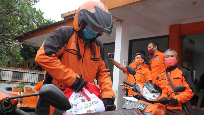 Mensos Juliari P Batubara (tengah), bersama Dirjen Perlindungan dan Jaminan Sosial Kemensos RI Pepen Nazaruddin (batik coklat kacamata), memberikan secara simbolis bantuan sembako kepada perwakilan warga di Kantor Pos, Rawamangun, Jakarta, Jumat (24/4/2020). Sebanyak 1,3 juta keluarga terdampak wabah covid 19 mendapatkan bantuan sembako presiden RI melalui Kementerian Sosial RI.