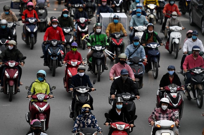 Motorists wearing face masks ride on a busy road in Hanoi on April 23, 2020, as Vietnam eased its nationwide social isolation effort to prevent the spread of the COVID-19 novel coronavirus. (Photo by Nhac NGUYEN / AFP)