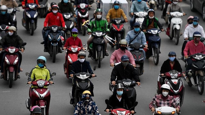 Motorists wearing face masks ride on a busy road in Hanoi on April 23, 2020, as Vietnam eased its nationwide social isolation effort to prevent the spread of the COVID-19 novel coronavirus. (Photo by Nhac NGUYEN / AFP)