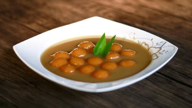 Biji salak on wood background. Biji salak is sweet potato dumplings with coconut sauce. Popular dessert in Indonesia or to break the fast.