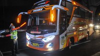 Polisi menghalau mobil bus yang membawa pemudik di tol Jakarta-Cikampek untuk keluar ke Gerbang tol Cikarang Barat, Kabupaten Bekasi, Jawa Barat, Jumat (24/4/2020). ANTARA FOTO/Fakhri Hermansyah.