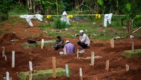 Padahal pemerintah telah melakukan imbauan dan pelarangan agar para peziarah tak perlu melakukan kunjungan ke makam guna meminimalisir penyebaran virus Corona. Tampak warga yang berziarah mengenakan masker saat berdoa di salah satu pusara keluarganya yang meninggal akibat virus Corona.