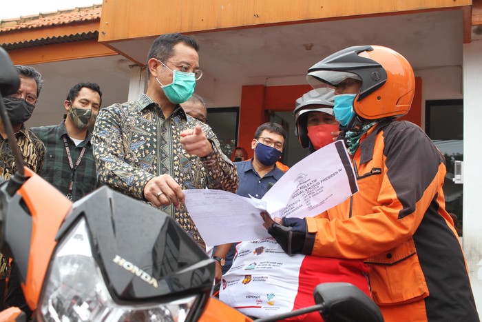 Distribusi Penyaluran Bantuan Sembako Mensos Juliari P Batubara (tengah), bersama Dirjen Perlindungan dan Jaminan Sosial Kemensos RI Pepen Nazaruddin (batik coklat kacamata), memberikan secara simbolis bantuan sembako kepada perwakilan warga di Kantor Pos, Rawamangun, Jakarta, Jum'at (24/4/2020). Sebanyak 1,3 juta keluarga terdampak wabah covid 19 mendapatkan bantuan sembako presiden RI melalui Kementerian Sosial RI.