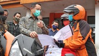 Mensos Juliari P Batubara, melepas tim PT POS Indonesia yang sudah ditunjuk untuk mengantar bantuan sembako di Kantor Pos, Rawamangun, Jakarta, Jumat (24/4/2020). Foto: dok. Kemensos
