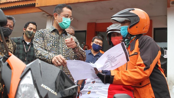 Mensos Juliari P Batubara (tengah), bersama Dirjen Perlindungan dan Jaminan Sosial Kemensos RI Pepen Nazaruddin (batik coklat kacamata), memberikan secara simbolis bantuan sembako kepada perwakilan warga di Kantor Pos, Rawamangun, Jakarta, Jumat (24/4/2020). Sebanyak 1,3 juta keluarga terdampak wabah covid 19 mendapatkan bantuan sembako presiden RI melalui Kementerian Sosial RI.
