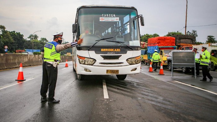 Petugas kepolisian berjaga saat dilakukan penyekatan kendaraan di pintu keluar Tol Bitung, Kabupaten Tangerang, Banten, Jumat (24/4/2020). Penyekatan itu dilakukan menyusul adanya larangan mudik bagi seluruh kalangan yang sudah ditetapkan mulai hari ini guna mencegah penyebaran COVID-19. ANTARA FOTO/Fauzan/wsj.