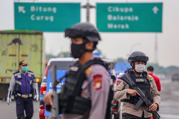 Petugas kepolisian berjaga saat dilakukan penyekatan kendaraan di pintu keluar Tol Bitung, Kabupaten Tangerang, Banten, Jumat (24/4/2020). Penyekatan itu dilakukan menyusul adanya larangan mudik bagi seluruh kalangan yang sudah ditetapkan mulai hari ini guna mencegah penyebaran COVID-19. ANTARA FOTO/Fauzan/wsj.
