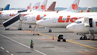Petugas melintas di sejumlah pesawat yang terparkir di Terminal 1 Bandar Udara Internasional Juanda, Sidoarjo, Jawa Timur, Sabtu (25/4/2020) yang ditutup. ANTARA FOTO/Umarul Faruq.
