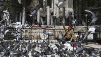 Hanya terlihat ada seorang pria yang memberi makan merpati di halaman Masjid Sultan Eyup di Istanbul, saat memasuki hari pertama bulan suci Ramadhan meskipun masjid itu ditutup dan tidak menggelar kegiatan.