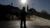 Hanya tampak seorang pekerja kota yang terlihat membersihkan jalan di luar stasiun metro Golden Horn, di Istanbul, Jumat (24/4/2020) kemarin yang juga bertepatan dengan hari pertama bulan puasa Ramadhan.