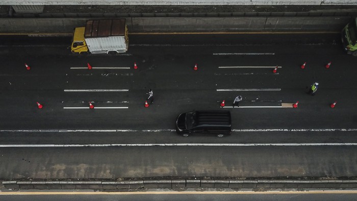 Petugas kepolisian membuat cek point pemeriksaan di dalam tol Jakarta Cikampek. Hal itu dilakukan untuk cegah warga mudik guna putus rantai penyebaran COVID-19.
