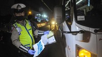 Polisi memeriksa surat ijin sopir mobil travel yang membawa tiga orang TKI ( Tenaga Kerja Indonesia ) dari luar negeri di tol Jakarta-Cikampek, Cikarang, Kabupaten Bekasi, Jawa Barat, Sabtu (25/4/2020). 