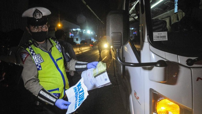 Petugas kepolisian membuat cek point pemeriksaan di dalam tol Jakarta Cikampek. Hal itu dilakukan untuk cegah warga mudik guna putus rantai penyebaran COVID-19.