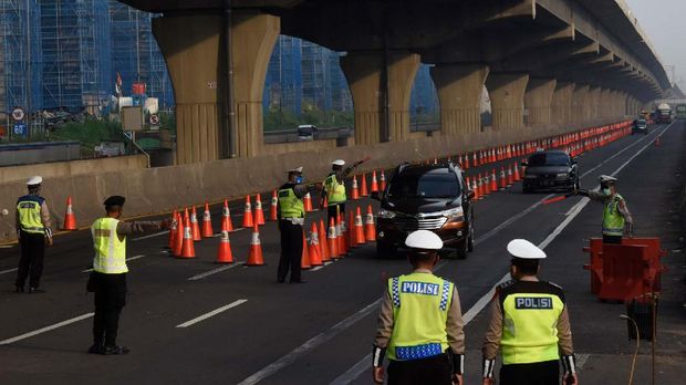 Petugas gabungan mengarahkan kendaraan untuk keluar Tol Cikarang Barat, di ruas Tol Cikampek, Jabar, Minggu (26/042020). Larangan mudik dan sosialisasi aturan Pembatasan Sosial Berskala Besar (PSBB) di ruas tol itu guna mencegah penyebaran COVID-19 dengan membatasi kendaraan pribadi dan angkutan umum yang melintas. ANTARA FOTO/Saptono/foc