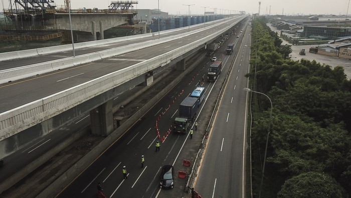 Petugas kepolisian membuat cek point pemeriksaan di dalam tol Jakarta Cikampek. Hal itu dilakukan untuk cegah warga mudik guna putus rantai penyebaran COVID-19.
