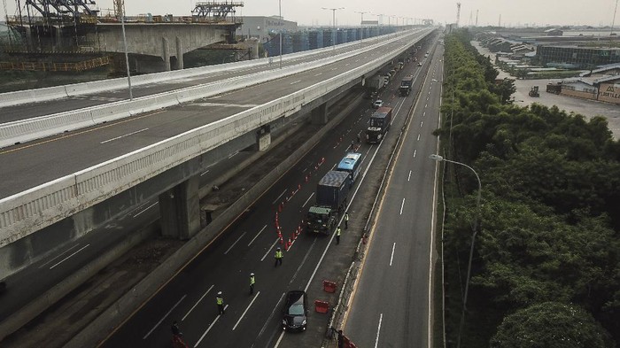 Petugas kepolisian membuat cek point pemeriksaan di dalam tol Jakarta Cikampek. Hal itu dilakukan untuk cegah warga mudik guna putus rantai penyebaran COVID-19.