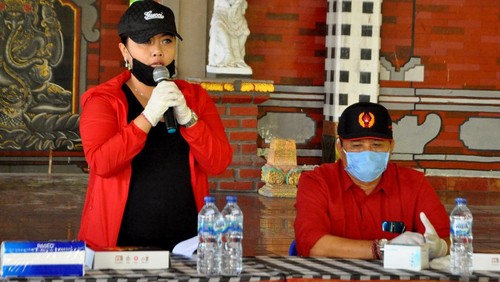 Bupati Tabanan Bali sekaligus Pembina Yayasan Ekalawya, Ni Putu Eka Wiryastuti (kanan) membagikan ribuan sembako, masker dan hand sanitizer gratis kepada masyarakat miskin baru imbas dari PHK perusahaan karena wabah corona seperti supir angkot, pedagang kaki lima, pelaku pariwisata dan sebagainya di Kabupaten Tabanan, Bali pada Minggu (26/4).