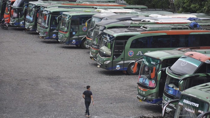 Seorang sopir berjalan di depan jajaran bus antarkota antarprovinsi (AKAP) yang dikandangkan di kawasan Medan Amplas, Sumatera Utara, Minggu (26/4/2020). Sejak adanya pembatasan mobilitas larangan mudik yang dilakukan oleh pemerintah guna mencegah penyebaran COVID-19, sejumlah pengusaha perusahaan otobus AKAP terpaksa mengandangkan armada sementara serta merumahkan supir dan kondektur akibat menurunnya pendapatan. ANTARA FOTO/Septianda Perdana/aww.