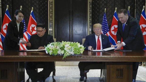 FILE - In this June 12, 2018, file photo, North Korea leader Kim Jong Un, center left, and U.S. President Donald Trump, center right, prepare to sign a document at the Capella resort on Sentosa Island in Singapore. At the last minute, Kim's sister, Kim Yo-jong, far left, provided a pen of her own for his use. Kim Jong Un's disappearance from the public eye is raising speculation about not only his health but also about who's next in line to run North Korea if anything happens to the leader. Some experts say his sister and close associate Kim Yo Jong is most likely since North Korea has been ruled by the Kim family for seven decades.  (AP Photo/Evan Vucci, File)