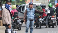 Pedagang sarung tangan menawarkan dagangannya kepada pengendara motor yang melintas di kawasan Kota Bandung, Jawa Barat, Minggu (26/4/2020).