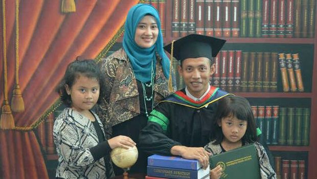 Suryo Agung Wibowo saat pose foto wisuda bersama istri dan kedua anaknya.