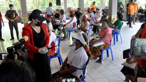 Bupati Tabanan Bali sekaligus Pembina Yayasan Ekalawya, Ni Putu Eka Wiryastuti (kanan) membagikan ribuan sembako, masker dan hand sanitizer gratis kepada masyarakat miskin baru imbas dari PHK perusahaan karena wabah corona seperti supir angkot, pedagang kaki lima, pelaku pariwisata dan sebagainya di Kabupaten Tabanan, Bali pada Minggu (26/4).