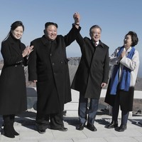 Meski fashion Korea Utara disebut kuno, namun Ibu Negara Korut ini tampil stylish memilih coat berpotongan feminin dengan boots senada. (Foto: Getty Images/Pool)