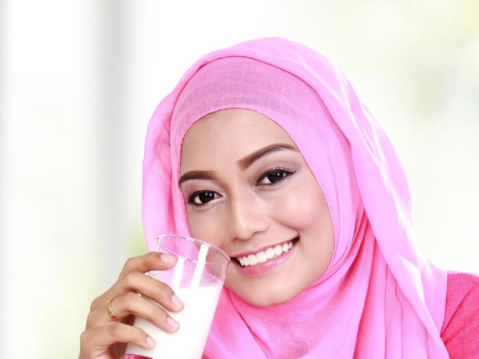 Ilustrasi susu almond kurma Banana and chocolate smoothie in two jars, protein milkshake, nuts, chocolate cubes, dates, cinnamon sticks, healthy eating on a dark background.