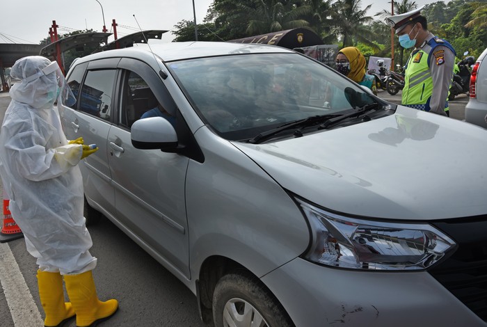 Personel gabungan Dishub, TNI, Polri serta petugas medis memeriksa pengendara keluar di pintu tol Serang Timur, di Serang, Banten, Senin (27/4/2020). Pengawasan dan penyekatan mobilitas di pintu masuk menuju Kota Serang dan Wilayah Banten Selatan itu dilakukan untuk mencegah gelombang arus mudik lebaran di tengah pandemi COVID-19. ANTARA FOTO/Asep Fathulrahman/hp.