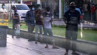 Pekerja migran mengantre pembagian makanan dengan memakai masker di Little India. Saat ini total kasus virus Corona di Singapura mencapai 13.624 kasus. Ore Huiying/Getty Images.
