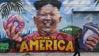 Seniman mural menggambar wajah Kim Jong Un memegang donat dan milkshake, di Los Angeles, AS (14/5/2018). Mural ini dibuat saat rencana pertemuan Kim Jong Un dan Donald Trump muncul ke publik. Pertemuan itu terlaksana sebulan kemudian di Singapura.