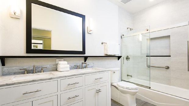 kamar mandi A contemporary modern bathroom design. featuring a bathtub with glass shower stall, toilet and his and her double sink vanity.