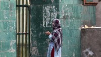 Seorang wanita Muslim Kashmir berdoa di luar gerbang tertutup sebuah kuil Muslim, India. Kuil-kuil Kashmir yang biasanya dipadati umat selama bulan suci Ramadhan sekarang sepi, ketika pihak berwenang menutup tempat suci itu untuk keselamatan masyarakat. AP/Mukhtar Khan