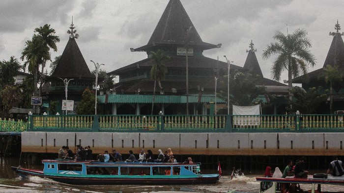 Perahu bermesin (kelotok) melintas di sungai kuin berlatar Masjid Sultan Suriansyah Banjarmasin, Kalimantan Selatan, Minggu (08/03/2020). Masjid Sultan Suriansyah merupakan masjid bersejarah dan salah satu masjid tertua di Kalsel berbahan kayu ulin yang menjadi salah satu tujuan wisata religi di Kalimantan Selatan. ANTARA FOTO/Makna Zaezar/hp.