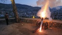 Seorang pria menembakkan sebuah kanon kuno untuk menandai berbuka puasa tak lama setelah matahari terbenam di Sarajevo, Bosnia. AP/Kemal Softic