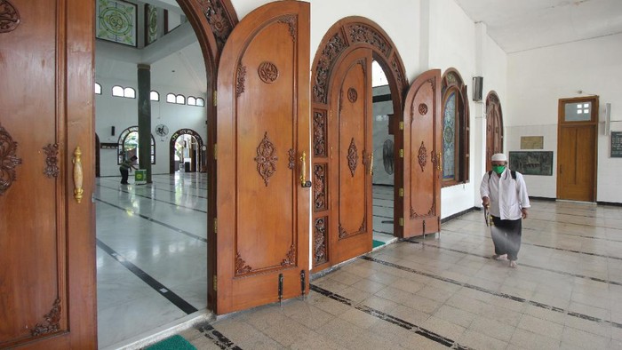 Pengurus masjid menyemprotkan larutan disinfektan di lantai Masjid Rahmat, Surabaya, Jawa Timur, Sabtu (25/4/2020). Masjid yang terletak di Jalan Kembang Kuning tersebut merupakan salah satu masjid tua di Surabaya dan peninggalan Sunan Ampel. ANTARA FOTO/Didik Suhartono/hp.