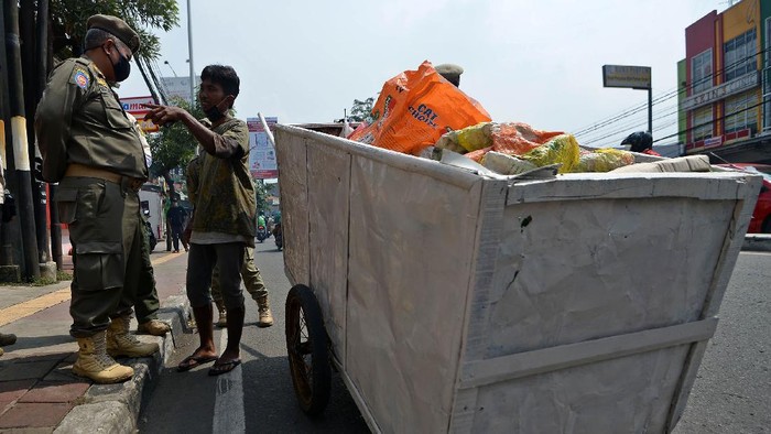 Sejumlah petugas Satpol PP mengamankan seorang penyandang masalah kesejahteraan sosial (PMKS) di Jalan Dewi Sartika, Cawang, Jakarta, Rabu (29/4/2020). Pemerintah Provinsi DKI Jakarta menggalakkan penertiban PMKS yang berkeliaran saat penerapan pembatasan sosial berskala besar (PSBB) untuk mencegah penyebaran COVID-19. ANTARA FOTO/Aditya Pradana Putra/aww.