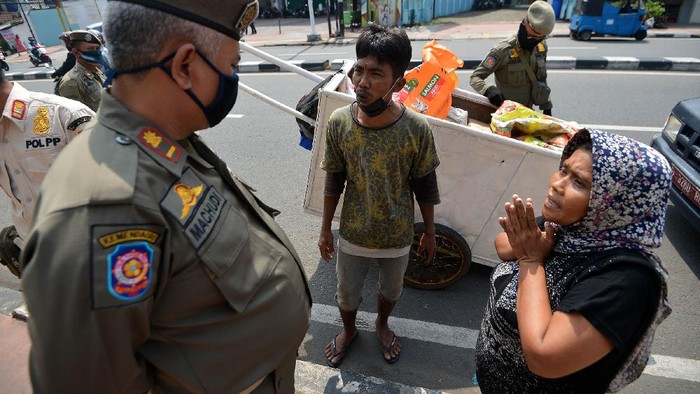 Sejumlah petugas Satpol PP mengamankan seorang penyandang masalah kesejahteraan sosial (PMKS) di Jalan Dewi Sartika, Cawang, Jakarta, Rabu (29/4/2020). Pemerintah Provinsi DKI Jakarta menggalakkan penertiban PMKS yang berkeliaran saat penerapan pembatasan sosial berskala besar (PSBB) untuk mencegah penyebaran COVID-19. ANTARA FOTO/Aditya Pradana Putra/aww.