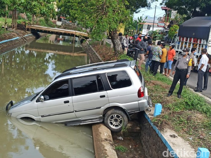 Mobil Isuzu Panther bernopol AE 1090 VE tercebur ke sungai di Jalan Ponorogo-Wonogiri KM 64. Pengemudi banting setir menghindari pemotor yang belok kanan.