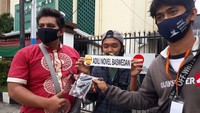 Dalam aksinya, mereka membagi-bagikan masker peduli corona bertuliskan Adili Novel Baswedan. Foto: Istimewa.