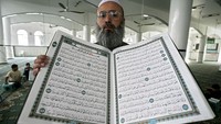 Seorang warga muslim, memegang salinan Alquran usai mengajar anak-anak Palestina membaca buku suci Muslim di dalam Masjid Marj AL-Zohor, di Kota Gaza, Jalur Gaza. Abid Katib/Getty Images.