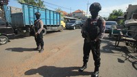 Polisi berjaga dari jarak jauh agar masyarakat tak mendekat ke lokasi penggeledahan.