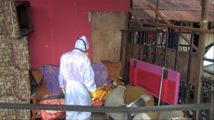 Tukang parkir di Samarinda dijemput relawan berbaju hazmat.