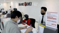 Teller Bank DKI tengah melayani nasabah dengan protokol pencegahan penyebaran COVID-19 di kantor layanan Bank DKI di Jakarta (30/4). Di tengah merebaknya pandemi COVID-19, Bank DKI masih dapat mencatatkan pertumbuhan kinerja keuangan yang positif. Foto: dok. Bank DKI
