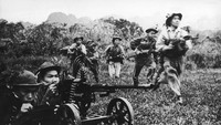 Para pasukan Viet Cong bergerak maju di bawah perlindungan senapan mesin berat di masa Perang Vietnam. Foto ini diabadikan sekitar tahun 1968.Three Lions/Hulton Archive/Getty Images.