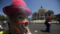 Aksi protes para badut tetap menggunakan masker dan topi pelindung. AP Photo/Fernando Llano.