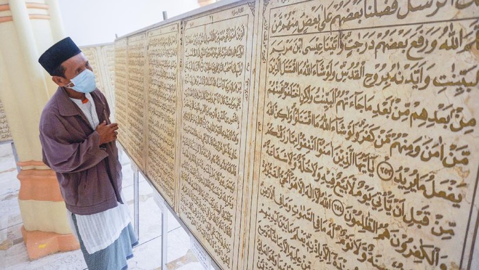 Warga mengamati ukiran Al Quran berbahan batu marmer di Masjid Al Muhtarom, Kabupaten Pekalongan, Jawa Tengah, Kamis (30/4/2020). Huruf Al Quran yang diukir secara manual di batu marmer impor dari Italia yang diukir seniman Indonesia Nurhidayat Sibah itu berjumlah 600 keping berukuran 60x90 centimeter dan tebal dua centimeter dengan berat total sekitar 14 ton. ANTARA FOTO/Harviyan Perdana Putra/aww.